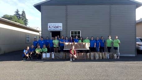 The TCA Vancouver team poses outside with the donations they collected for a local charity.